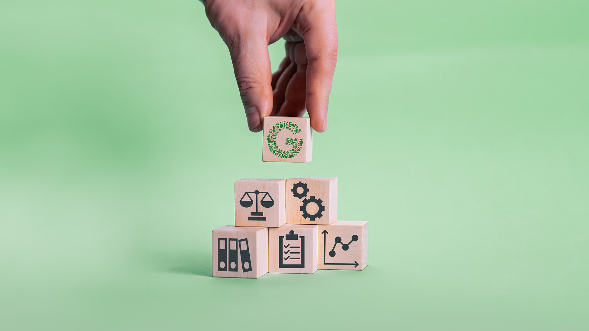 Image of a person assembling wooden blocks that represent the activities of the GLOBALG.A.P. Integrity Program