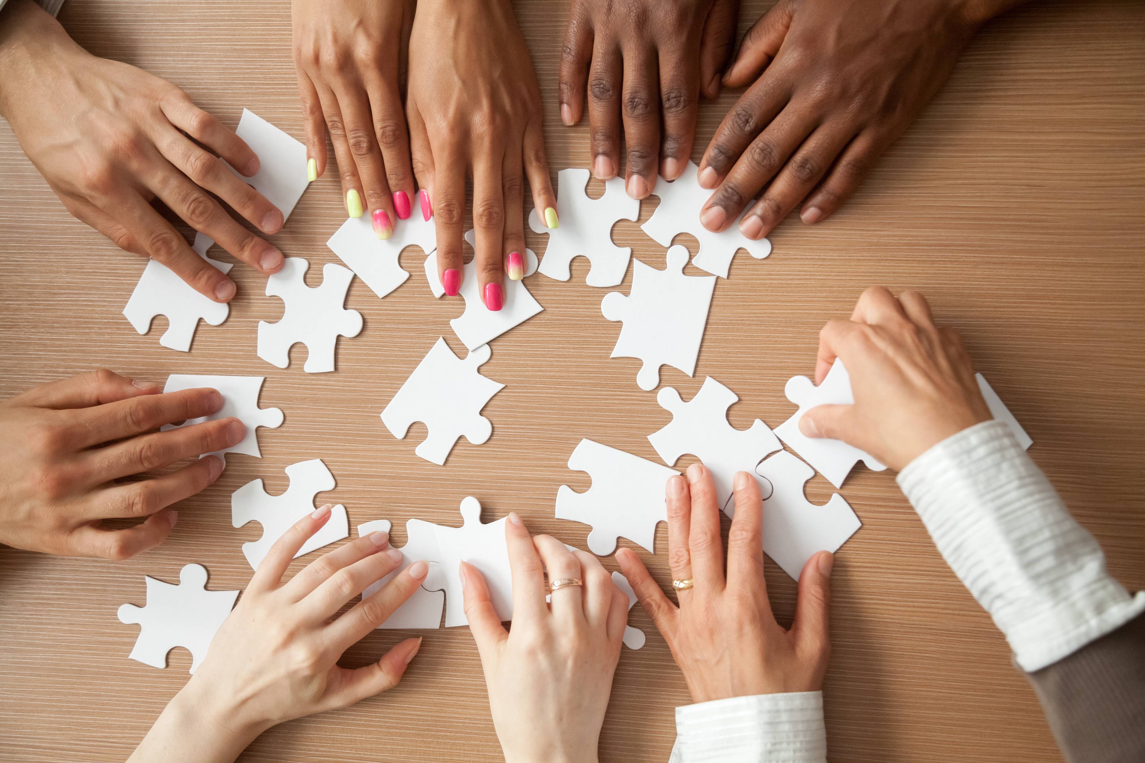 Image of team members arranging jigsaw pieces to find a solution