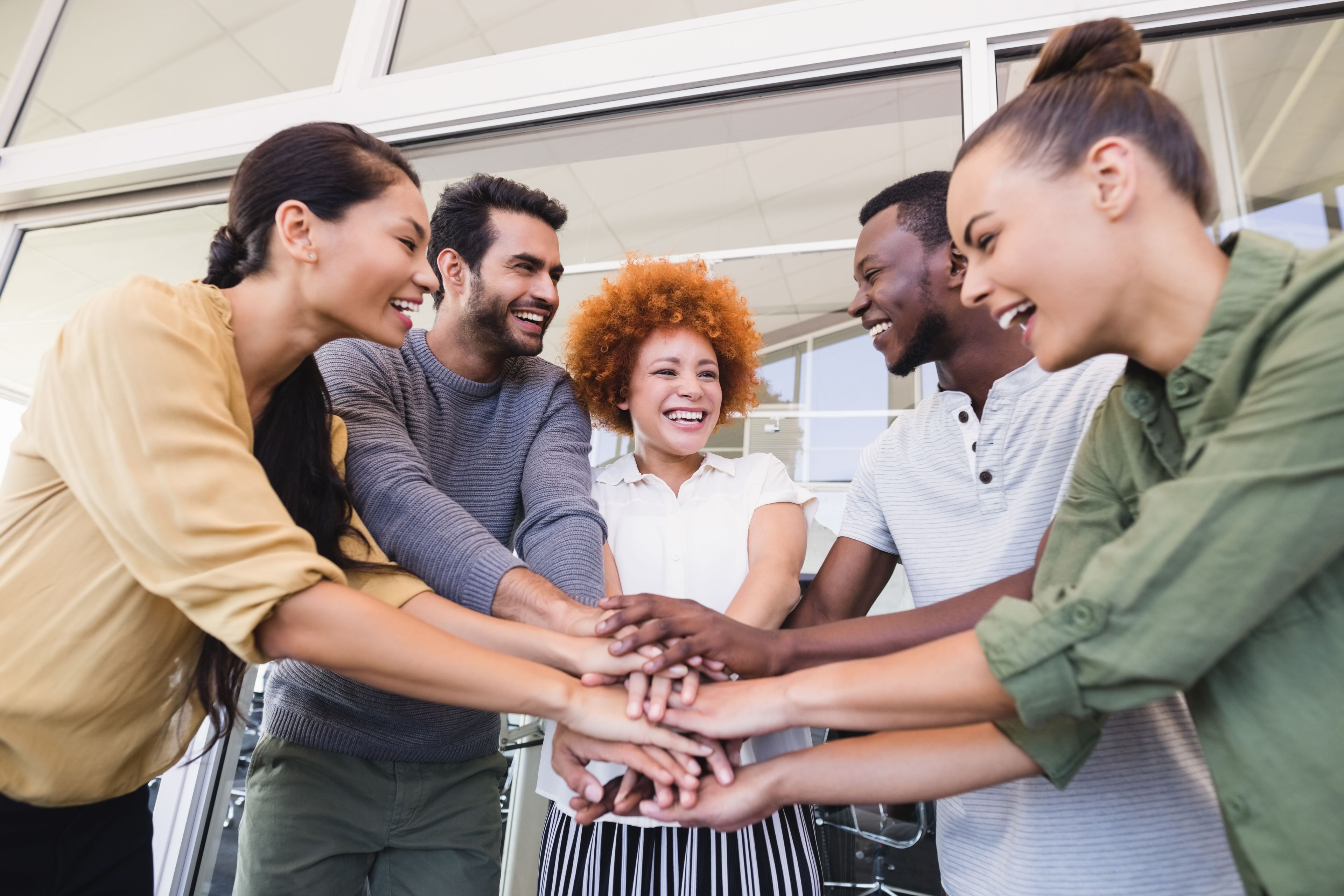 Image of team members joining hands to represent collaboration