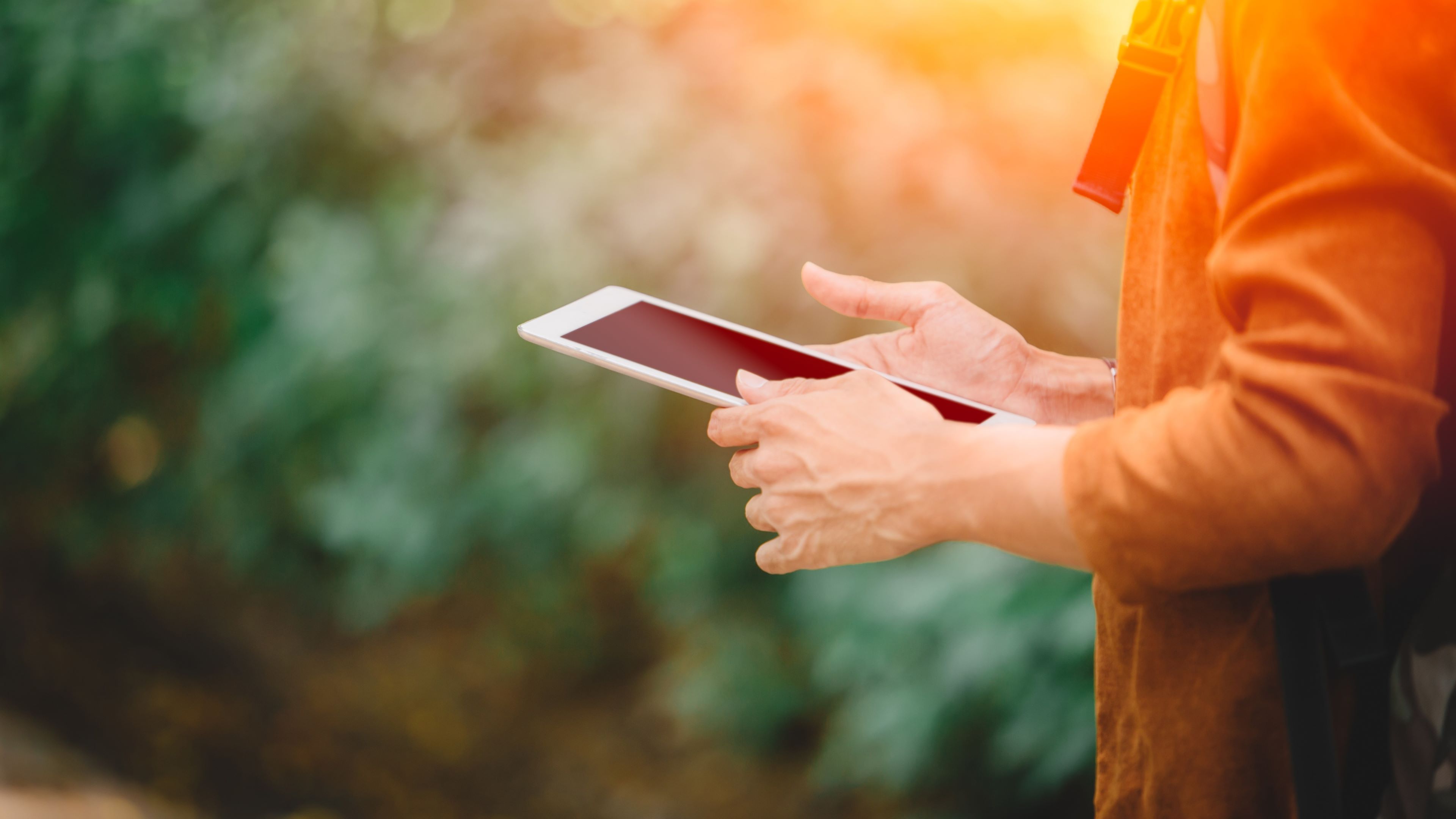 Image of a producer using a tablet to monitor farm inputs such as water and energy