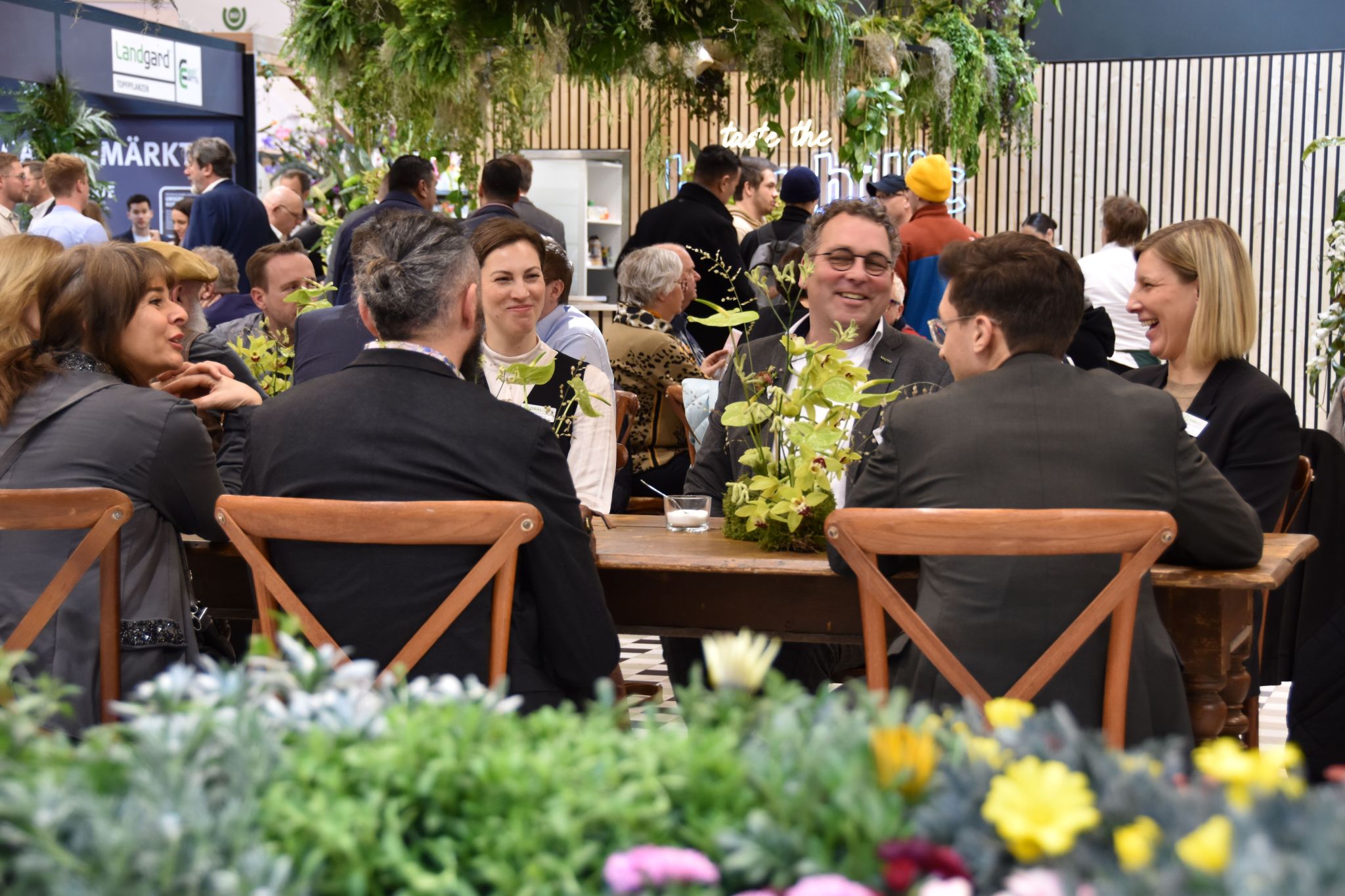 Networking and discussions take place among key stakeholders in the floriculture industry at the GLOBALG.A.P. booth at IPM 2024 trae fair in Essen, Germany. 