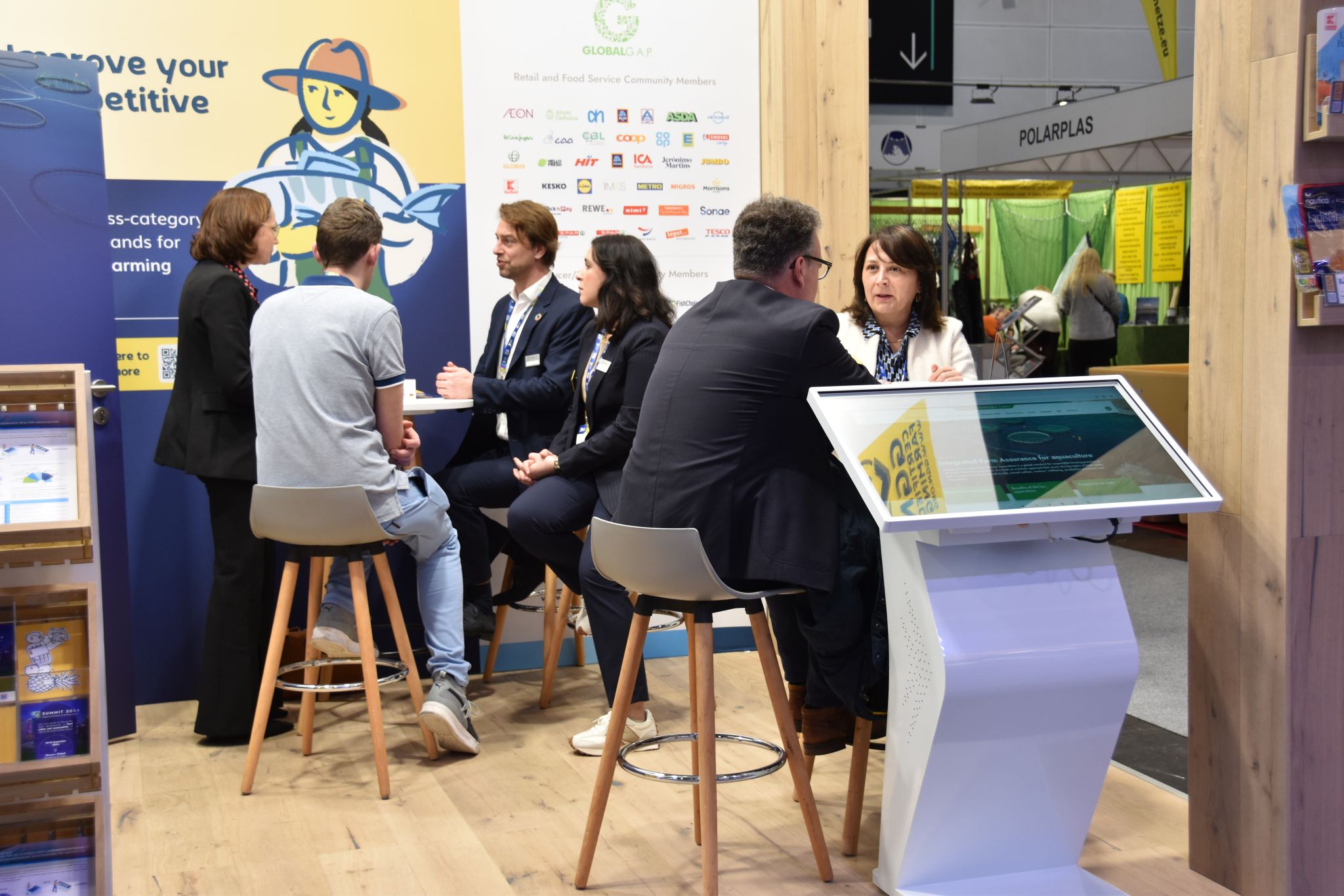 Stakeholders in conversation at the GLOBALG.A.P. and GGN label booth at Fish International 2024 in Bremen, Germany.